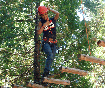 Girl on high ropes course in woods
