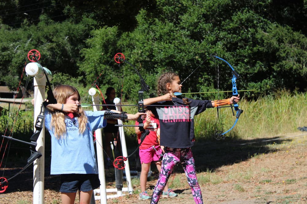 Girls shooting bow and arrow