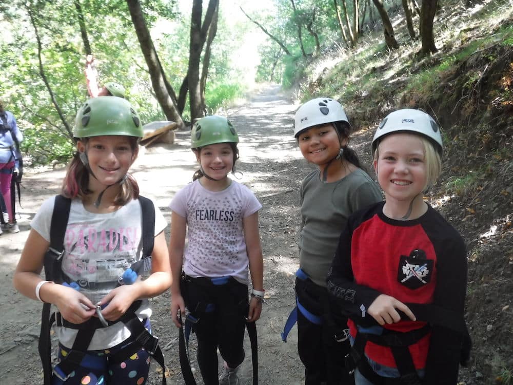 Group of smiling girls in helmets for ropes course