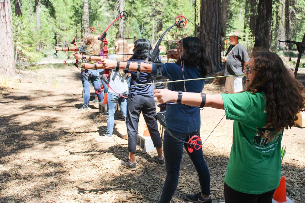 Campers shooting bow and arrow