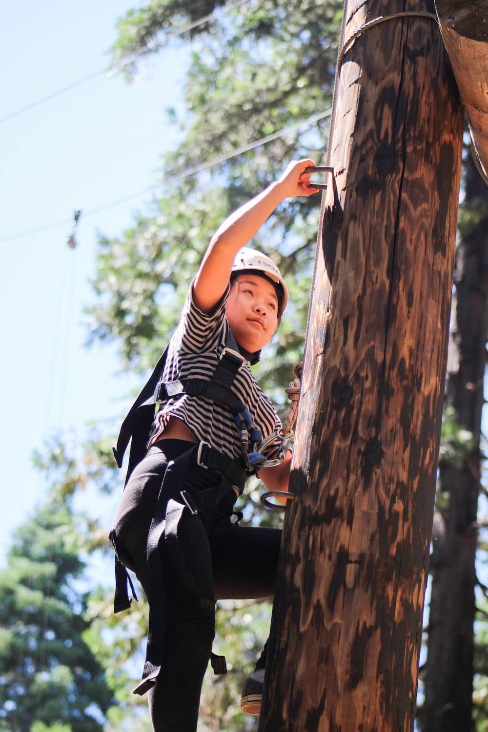 Camper climbing on high ropes course