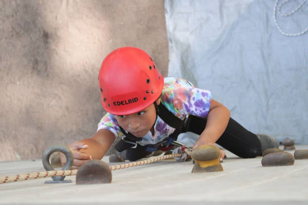 Girl camper rock climbing
