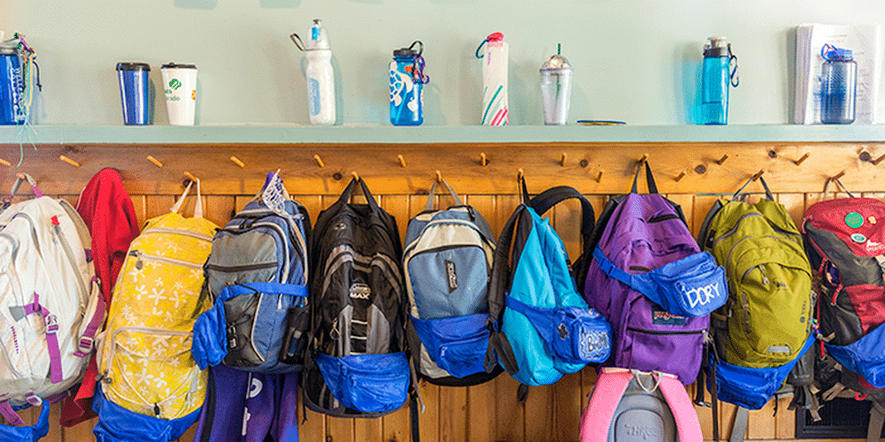 Image of colorful backpacks hanging next to each other