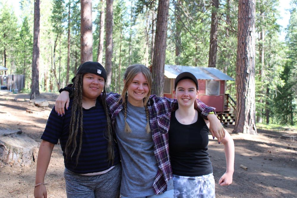 Three campers posing in woods for picture